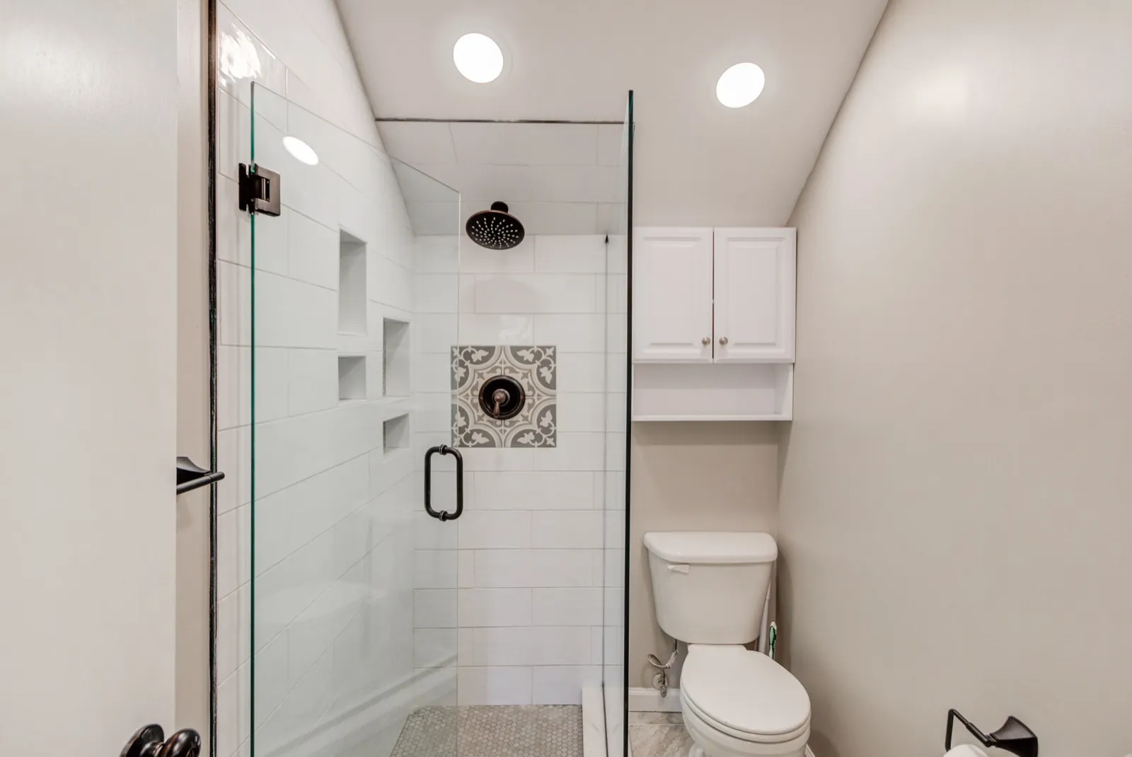 Bathroom remodeling for Alpharetta, GA homeowners: a JWAC walk-in glass shower with white subway tile and a patterned accent tile