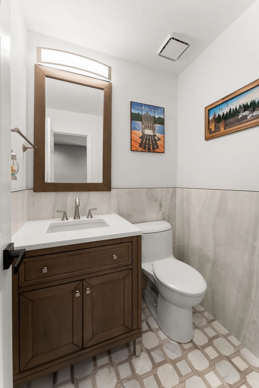 A wood vanity, tile wainscot and a patterned floor