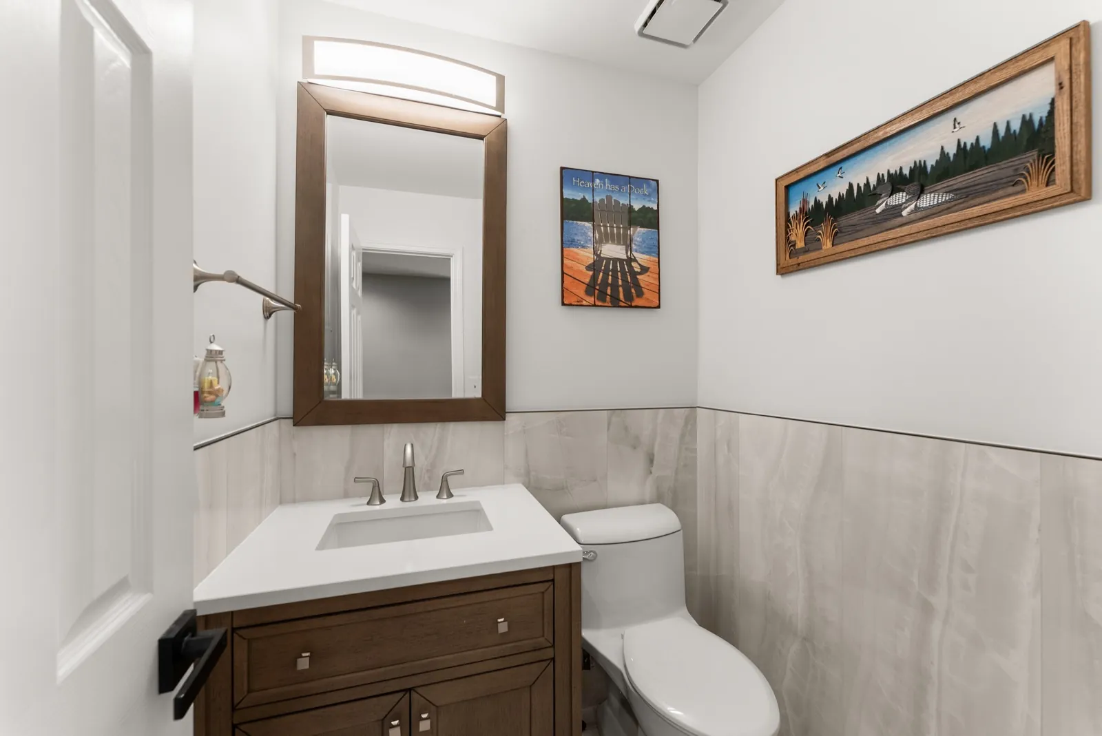 Bathroom remodeling for Lawrenceville, GA homeowners: a JWAC bathroom with a wood vanity and gray tile wainscot