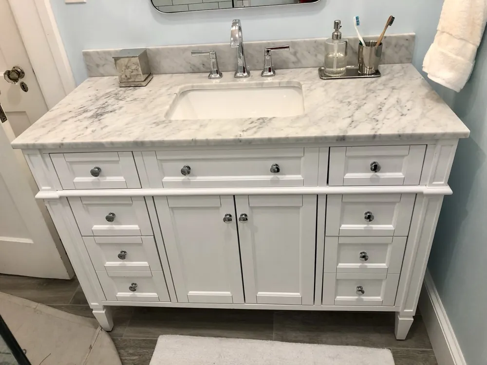 A white vanity with a marble top