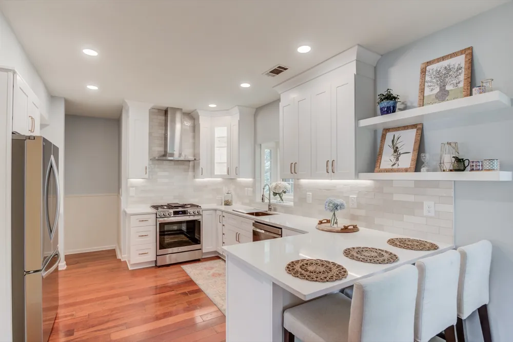 Floating shelves, a tiled backsplash and a peninsula with seating